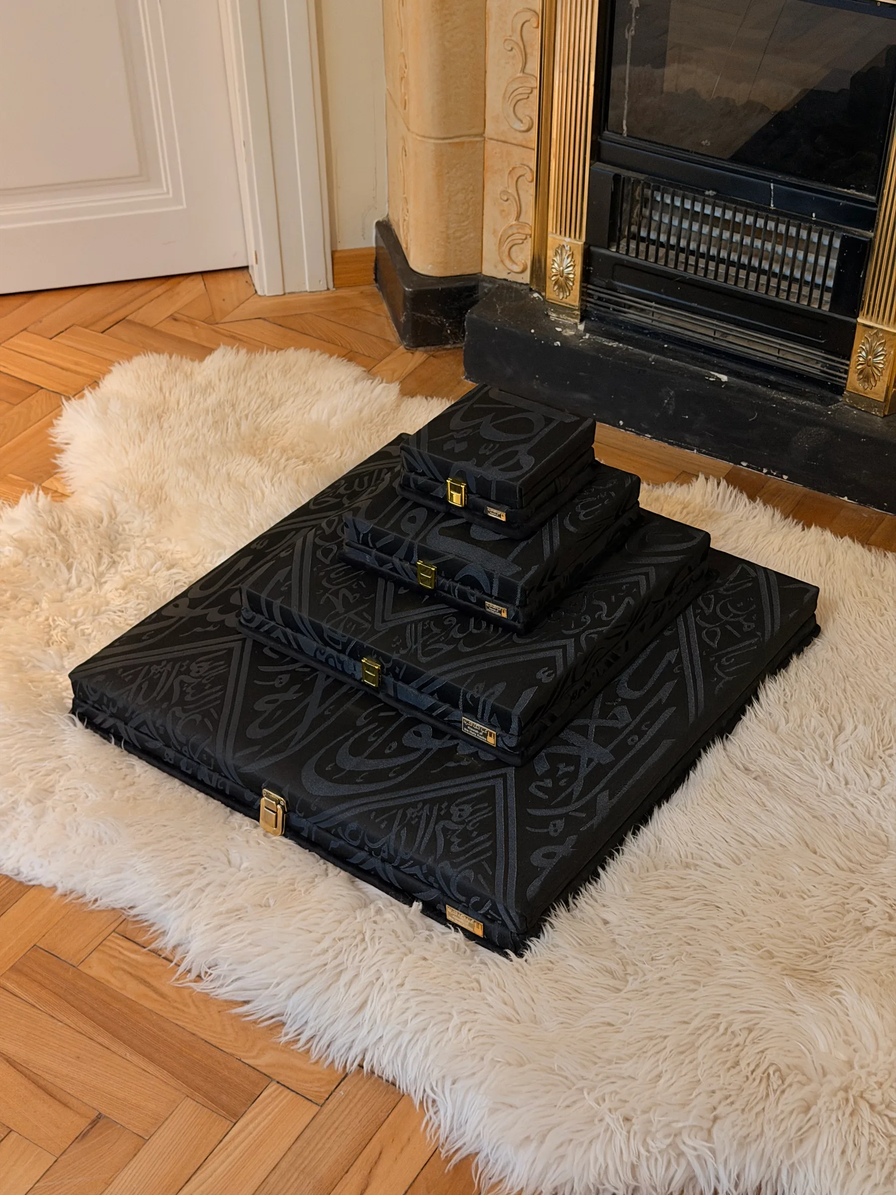 Four black Kiswah presentation boxes stacked as a pyramid