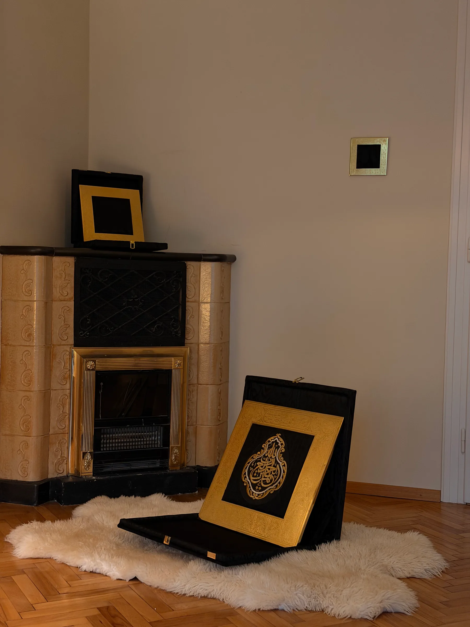 Kiswah frames displayed in a bright room with a tiled stove