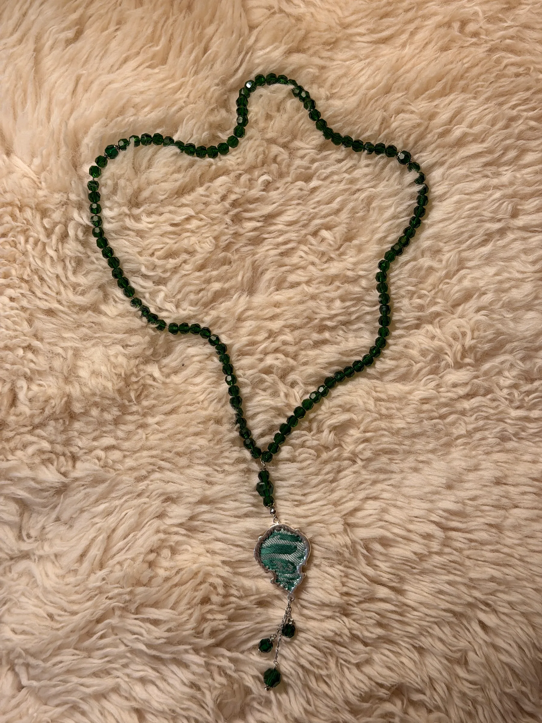 Chain of green crystal beads with a turquoise fabric pendant and beaded drops