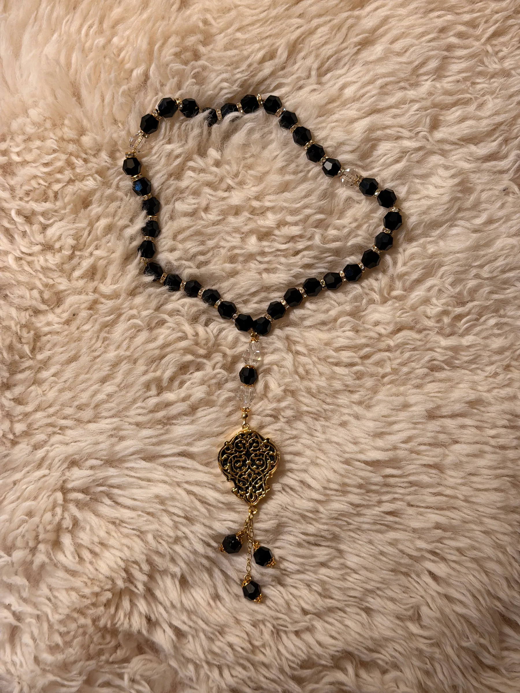 Black crystal bead chain with gold-tone spacers and a filigree medallion