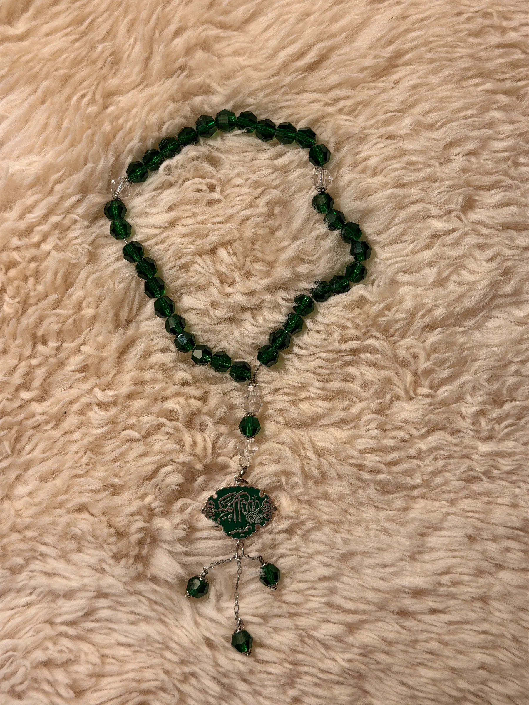 Green crystal bead chain with an engraved green medallion and crystal drops