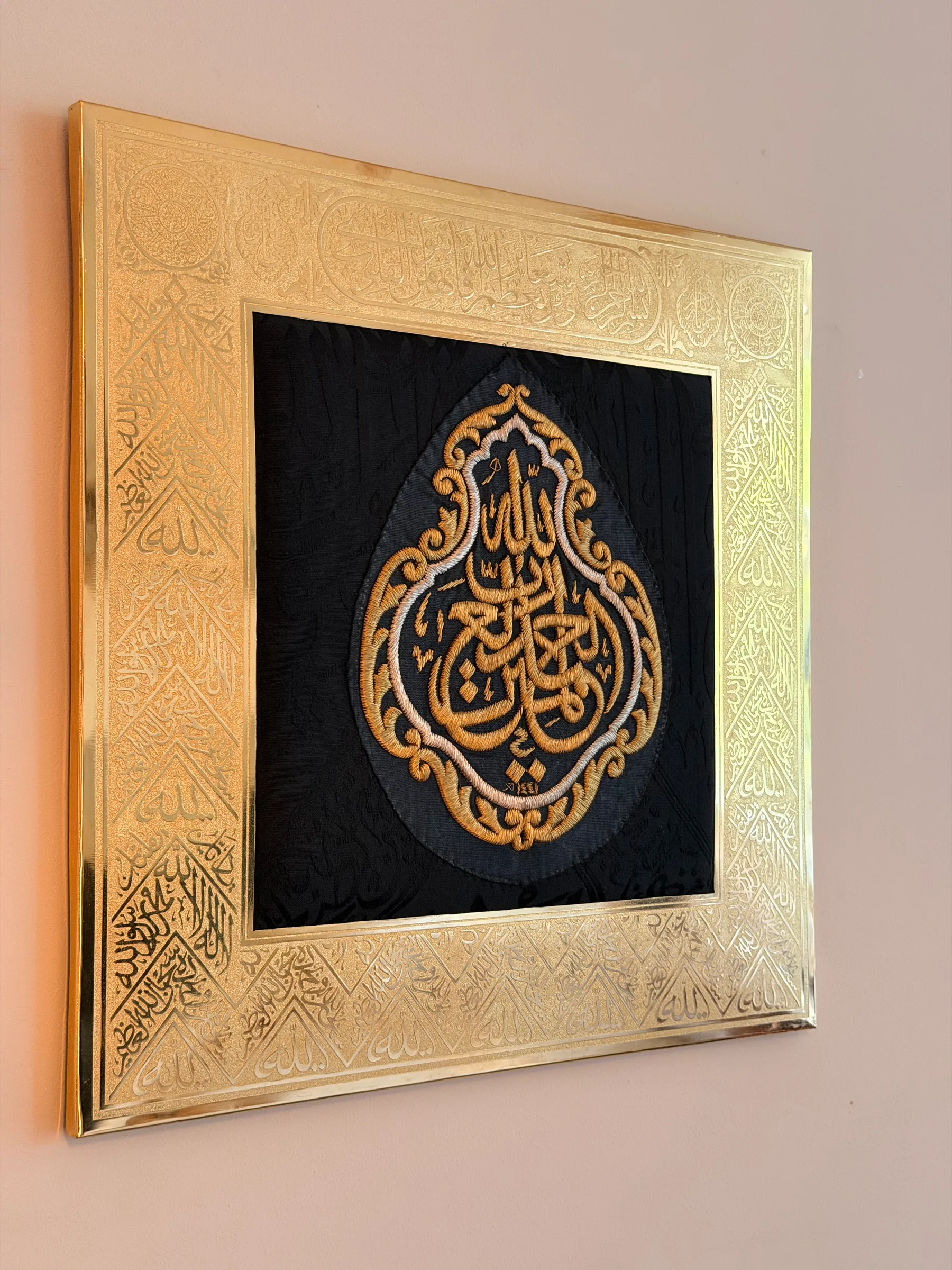 Large Kiswah frame photographed from the side, showing the engraved gilded copper frame