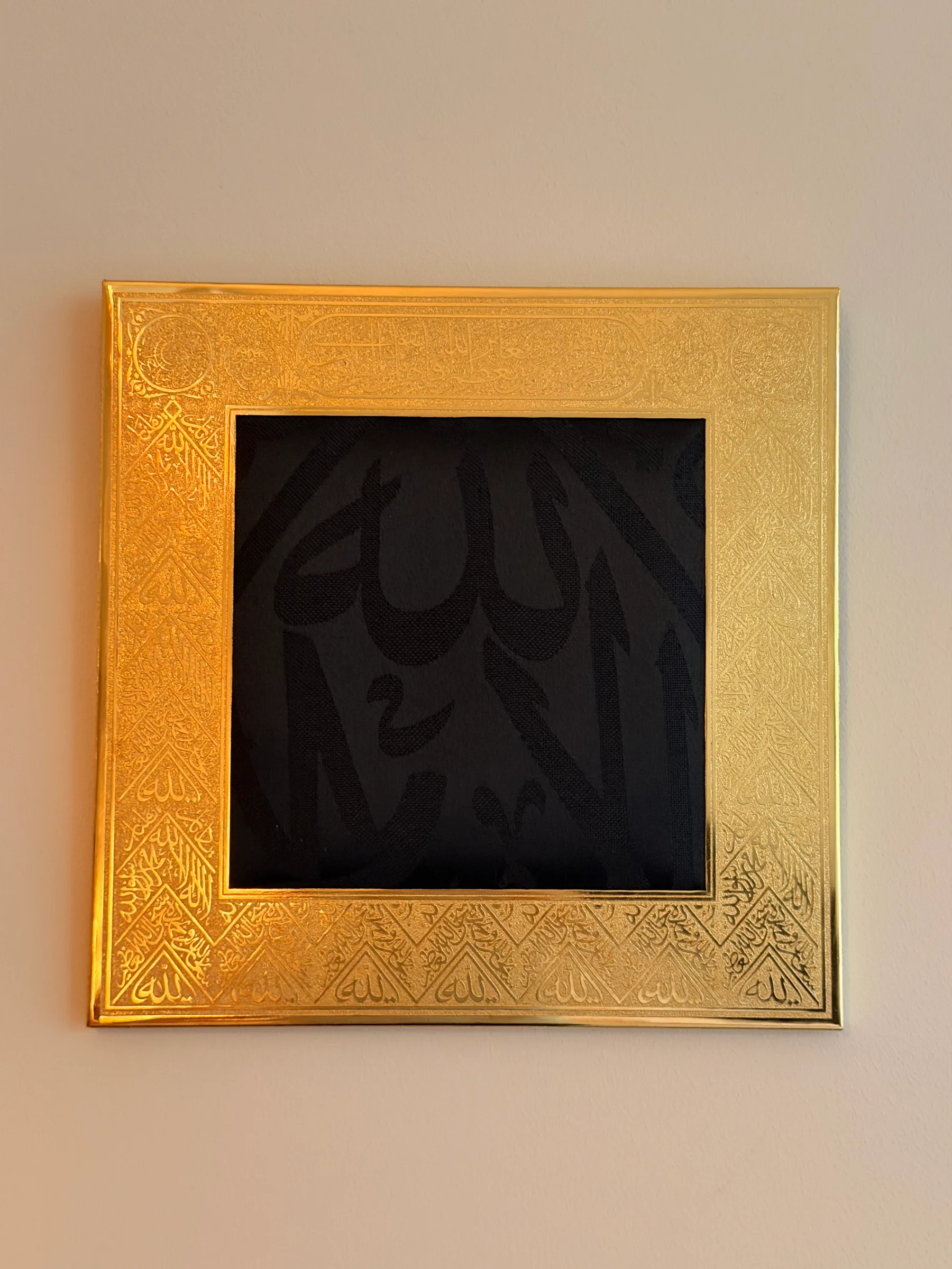 Medium Kiswah frame with woven black Kiswah fabric in a gilded frame